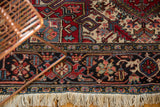 Detailed geometric border and original ivory fringe of a hand-knotted vintage Persian Heriz carpet.