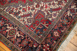 Detailed corner view of a vintage Heriz carpet showing geometric borders and cream fringe.