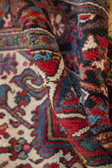 Plush, even wool pile of a hand-knotted Heriz carpet showing rich red and blue geometric details.