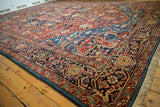 Angled view of an antique Bakshaish carpet corner highlighting the full wool pile and intricate border.