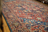 Low-angle view across the full pile of an antique Bakshaish rug, highlighting its complex gem-toned patterns.