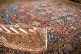 Vivid jewel tones and large-scale palmettes on the wool pile of an antique Persian Bakshaish carpet.