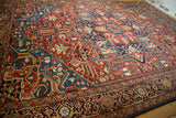 Vibrant ruby and sapphire tones in the complex geometric design of a collector's antique Bakshaish carpet.
