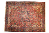Vintage Heriz carpet with a bold starburst medallion and geometric field in cherry red and navy blue.