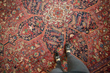 Detailed view of a vintage Heriz carpet's starburst medallion and dense geometric field.