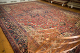 Angled perspective of an oversized vintage Heriz carpet's densely ornamented field and corner spandrels.