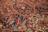 Geometric florals and delicate vinery in cherry red and navy on a vintage Heriz rug.