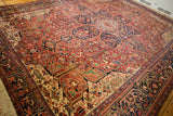 Angled view of an oversized vintage Heriz carpet showcasing its dense geometric pattern and full pile.