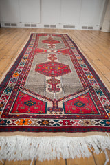 White fringe and rich cherry red, indigo border patterns of the vintage Serab runner.