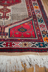 Ivory woven fringe and cherry red geometric border of a vintage Serab rug runner.