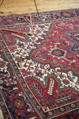 Angled detail of a vintage Mehrivan carpet's intricate pomegranate motifs in cherry red and navy blue.