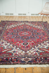 Angled room view of a vintage Mehrivan carpet showing its vibrant red and navy traditional pattern.