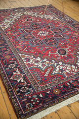Angled view of a vintage Mehrivan carpet's full pile and traditional design in cherry red and navy blue.