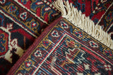 Intact ivory fringe and wine-red selvage on the full-pile corner of a vintage Mehrivan carpet.