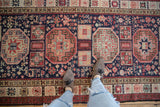 Top-down view of the vintage Ardebil runner showing its lush pile, geometric medallions, and playful animal motifs.