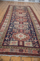 Angled view showing the column of geometric medallions on the vintage Ardebil runner.