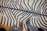 Faint abrashes in the hand-woven ivory and charcoal zebra kilim rug.
