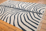 Hand woven vintage zebra kilim texture with charcoal stripes, faint abrashes, and ivory fringe.