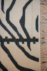 Hand woven vintage Kilim with textured charcoal zebra stripes and ivory fringe.