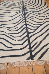 Creamy ivory fringe and charcoal zebra stripes of the hand woven vintage kilim rug.