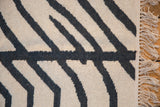 Detail of the modern zebra stripe Kilim rug with ivory and charcoal weaving and fringe.