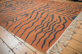 Vintage Indian Tiger Kilim rug detail with pale rust and dusty teal tiger stripes, showing fringe.
