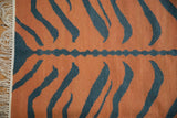 Cream fringe and handwoven pale rust and dusty teal tiger kilim pattern with central wavy stripe.