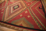 Serrated geometric patterns in red, beige, and green with the Soumac rug's intact selvage.