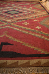 Red, black, and beige geometric border pattern with natural fringe on a vintage Soumac rug.