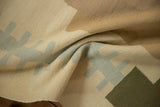 Contemporary Kilim rug's folded texture, featuring beige, light blue, and olive geometric patterns.