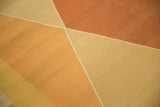 Detail of modern argyle diamond pattern on a hand-knotted Kilim in terracotta, gold, beige.