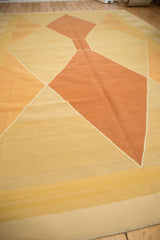 Close-up of contemporary Kilim carpet's Argyle-inspired diamond pattern in copper, gold, and ivory.