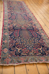 Vintage Kerman runner's navy millefleur design, cochineal red border, and visible even wear.