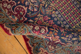 Vintage Kerman runner's curled edge reveals ornate navy, cochineal, and sky blue fleur-de-lis border.