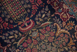 Vintage Kerman rug detail: sprawling millefleur pattern, navy, red, blue, with visible knot heads.