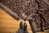 Folded vintage Hamadan runner displaying ivory Mir Serbend border and navy Herati motif.