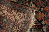 Tight hand-knotted back of a vintage Hamadan rug, showing beige, red, blue foundation and cream fringe.