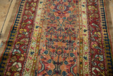 Angled view highlighting the varied pile and dense floral medallions of an antique Serab runner.
