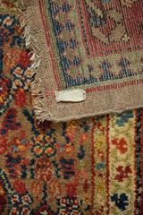 Back of an antique Serab runner showing the hand-knotted foundation weave and original tag.