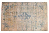 Vintage distressed Bulgarian Herati carpet with a faded blue medallion and gold tones over an antique ivory field.