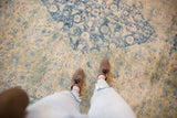 A view looking down at the soft, distressed texture of the vintage Bulgarian Herati carpet.