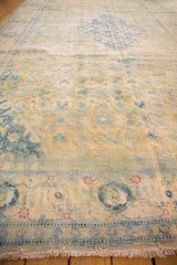 Angled view showing the worn, low-pile texture and floral border of a vintage Bulgarian carpet.