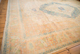 Corner of a vintage distressed Herati carpet with a pale terracotta border and ivory field.