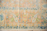 Softly distressed pile of a vintage Bulgarian rug with terracotta, ivory, and blue motifs.