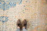 Looking down at the soft, distressed texture and faded Herati patterns in blue and terracotta.