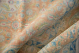 Evenly worn texture of the vintage rug's pile in soft copper and sky blue hues.