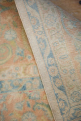 Intact side cord selvage and the low, distressed pile of the hand-knotted vintage carpet.