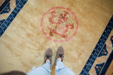 Blush and terra cotta five-clawed dragon motif on the vintage Peking carpet's gold field.