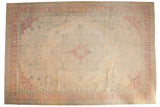 Distressed vintage Bulgarian Kerman carpet: ivory field, central floral medallion, faded red and blue cypress border.