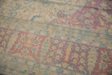 Distressed floral border details of a vintage Bulgarian Kerman rug in raspberry and sky blue tones.